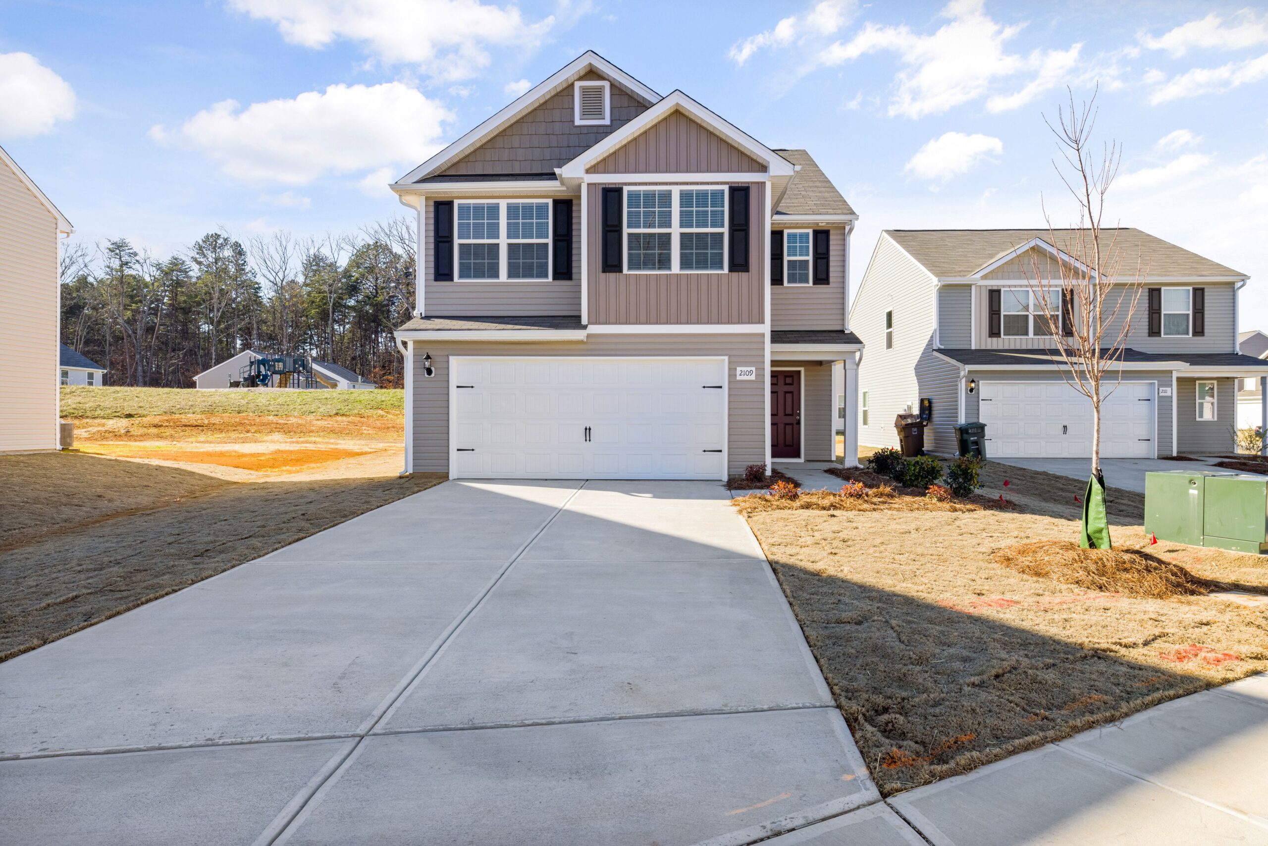 From Blueprint to Move-In: The Custom Home Build Timeline 2 Contemporary suburban house with a wide driveway and landscaped front yard.